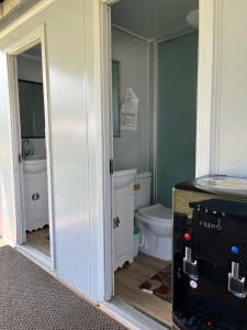 a bathroom with a toilet and a mirror at North Shore Glamping Camping Laie, Oahu, Hawaii in Laie