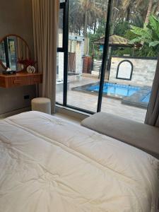 a bed in a bedroom with a view of a pool at Fursad Paradise in Shāq