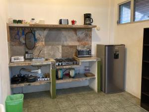 a kitchen with a stove and a refrigerator at Las Olas in Puerto Escondido