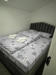 a bed with a white blanket with flowers on it at Vila Leona E3 in Divčibare