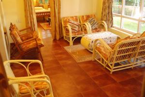 a living room with wicker chairs and a couch at Bella Vista Homestay in Coonoor