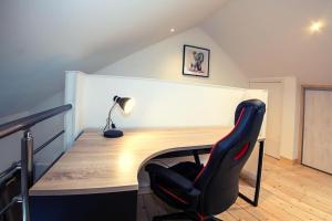 a desk with a chair and a lamp in a room at Le Clos de Tanvol - Parking privé GRATUIT- Terrasse Privée - Climatisation - Caravane Airstream in Viriat