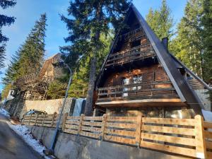 a log cabin in the woods with a fence at Vikendica Rajvosa Vlašić in Šišava
