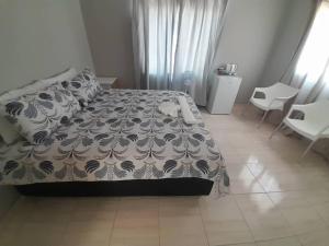 a bedroom with a bed and a table and chairs at Nosso Palacio Guest House in Rehoboth