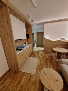 a kitchen and living room with a table and a couch at Apartman Vučko Dalia - Aparthotel Vučko in Jahorina
