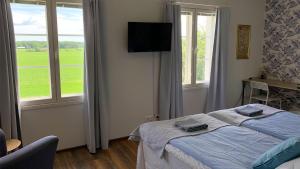 a bedroom with a bed with blue sheets and windows at Majatalo Elsa in Hirvihaara