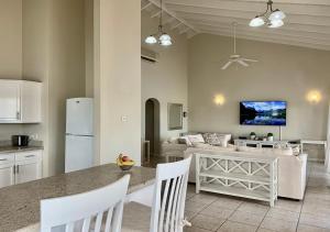 una cucina e un soggiorno con tavolo e sedie di Harbour View Penthouse a Gros Islet