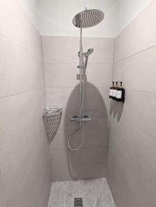 a shower with a shower head in a bathroom at L'Atelier des Rêves in Saverne