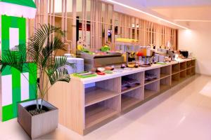 a restaurant with a counter with food on it at favehotel Palembang in Palembang