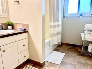 Un baño con lavabo y ducha en Cozy Walkout suite with King bed, Kitchen, Parking & Patio, en Calgary 20 fotos más