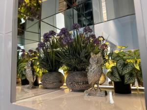 an owl statue sitting on a table with flowers at Old Cracow Apartment I in Krakow