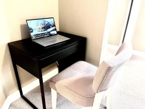 escritorio con ordenador portátil y silla en Cozy Walkout suite with King bed, Kitchen, Parking & Patio, en Calgary