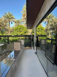 a hallway of a building with glass windows and palm trees at Fursad Paradise in Shāq