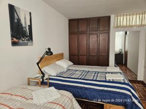 a bedroom with two beds and a cabinet at Departamento Los Sauces in Cajamarca