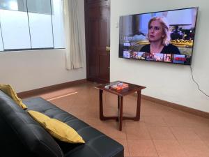 a living room with a couch and a tv on a wall at Departamento Los Sauces in Cajamarca