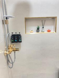 a bathroom with a shower and a shelf with plants at Fursad Paradise in Shāq +41 photos