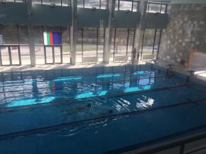 a large swimming pool with blue water in a building at Guest Apartment Elina in Smolyan