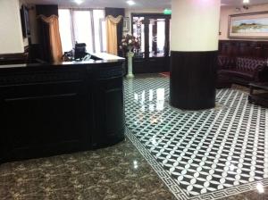 a lobby with a black and white tiled floor at Hotel Baden in Călăraşi