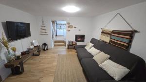 a living room with a couch and a tv at Casa do Serro de Lá in Santa Clara-a-Nova
