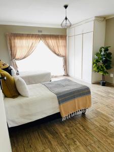 a bedroom with a bed with a large window at Chatsvilla in Boksburg +14 photos