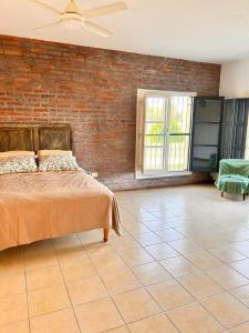 a bedroom with a bed and a brick wall at Estancia El Sosiego in Gualeguay