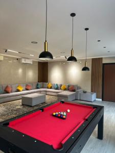 a living room with a red pool table at Fursad Paradise in Shāq