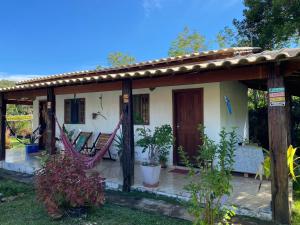 a house with a hammock in front of it at Chalé do João e do Chico Garfield in Jaboticatubas
