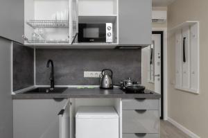 a small kitchen with a sink and a microwave at Затишна квартира поруч з метро Харківська in Kyiv