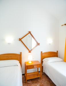 a bedroom with two beds and a mirror on the wall at Bungalows Las Almenas in Maspalomas +59 photos