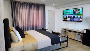 una camera da letto con un letto e una TV a schermo piatto di Hotel MAXIMUM COMFORT FCA a Salinas
