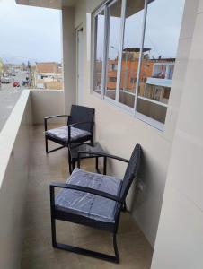 2 sedie e una panca sul balcone di Hotel MAXIMUM COMFORT FCA a Salinas