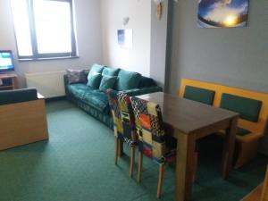 科帕奥尼克Kopaonik Vila Nikola 306 centar的客厅里有一张沙发和一张桌子。