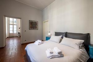 a bedroom with a large white bed with towels on it at Top Living Apartments - De Lellis Torino Centro in Turin +131 photos