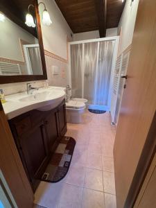 Villa Paterno في Amandola: حمام مع حوض ومرحاض ومرآة