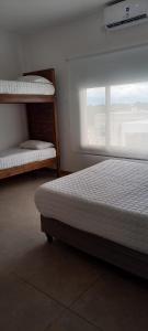 a bedroom with two bunk beds and a window at La Morada Apart in Cafayate +8 photos