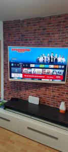 a television hanging on a brick wall at MO HOME24 in Cologne
