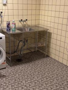 a bathroom with a sink in a tiled room at Noah Longstay Stafettgatan 42 in Västerås
