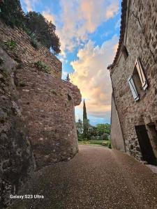 an alley in a stone wall with a building at Le Château de Soleil in Saint-Pons-de-Mauchiens