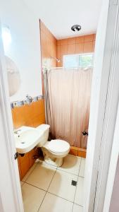 a bathroom with a toilet and a sink at Golden Sunset House in Acajutla +19 photos