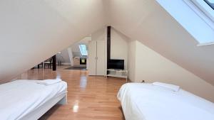 a attic bedroom with two beds and a television at Zentrale Monteurwohnung Neumünster mit Küche & WLAN in Neumünster