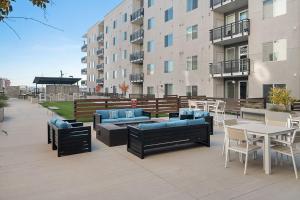 a patio with couches and tables and a building at Gorgeous 2BD 2BA Pool,Gym,Htub near Convention Ctr in Salt Lake City