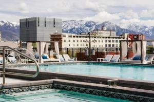 a swimming pool with chairs and mountains in the background at Gorgeous 2BD 2BA Pool,Gym,Htub near Convention Ctr in Salt Lake City
