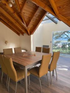 a dining room with a wooden table and chairs at Casa Bosque in Ushuaia