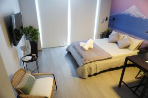 サンティアゴにあるDepartamento full equipado a pasos del movistar arena, moderno y cómodo con toda la magia del surのベッドとテーブルと椅子のある寝室 +34枚の写真