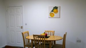 a table and chairs with a bowl of fruit on it at A Place to Pause, A Place to Belong, Charming Three Bedroom Rainham Retreat with Parking and WiFi in Swindon