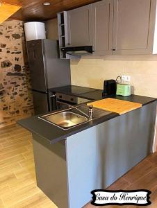 a kitchen with a sink and a refrigerator at Casa do Henrique in Bragança
