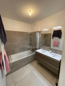 une salle de bain avec une baignoire, un lavabo et une douche dans l'établissement Large apartment with air conditioning, terrace and parking, à Montpellier 6 autres photos