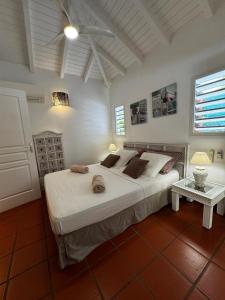 a bedroom with a large white bed and a table at Villa Douceur & Spa Piscine & Jacuzzi privés - proche plage in Saint-François +25 photos