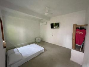 Habitación con cama y camisa roja en la pared en Vila 34, en Porto Seguro