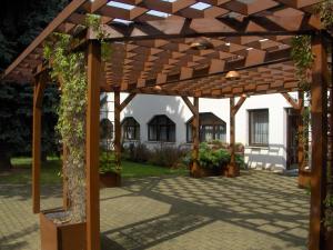 a wooden pergola in front of a house at Hotel Amos in Fulnek